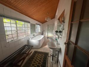 a bathroom with two sinks and a tub and a toilet at Tucker House B&B in Kimberley