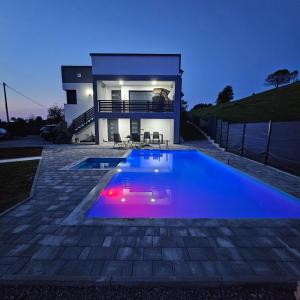 a swimming pool in front of a house at night at Villa Vienna in Bužim +23 photos