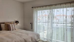 Un dormitorio con una cama y una ventana grande en Fantástica V3 Vista Mar & Golfe Praia Del Rey, Óbidos, en Amoreira 43 fotos más