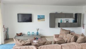 Una sala de estar con un sofá y un televisor. en Fantástica V3 Vista Mar & Golfe Praia Del Rey, Óbidos, en Amoreira