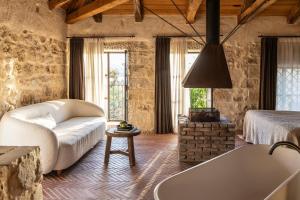 a living room with a bath tub and a bed at Amalen Suites Adults Only in Rethymno