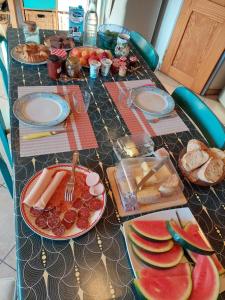 a long table with plates of food on it at Les Maisons de Gaia Chambres d'hôtes climatisées in Tuchan