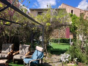 a garden with two chairs and a gazebo at Les Maisons de Gaia Chambres d'hôtes climatisées in Tuchan