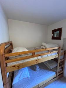 ル・ラヴァンドゥーにあるAPPARTEMENT ET SA JOLIE TERRASSE Le Lavandou Saint Clair, a deux pas de la plage de St Clair, au calme, Studio tout équipé, clim, Wifi Fibre, TV connectée, lave linge, lave vaisselle, place de parking et plus, serviettes et draps fournisの二段ベッドが2つある寝室 +12枚の写真