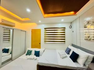 a bedroom with a large white bed with blue pillows at Full House Santa Ana in Sampong +20 photos