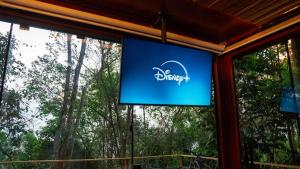 a blue sign on a window with trees in the background at Tucano - Deck Tiny House in Mairiporã