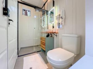 a bathroom with a toilet and a glass shower at Tucano - Deck Tiny House in Mairiporã +18 photos