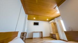 a room with a bed and a wooden ceiling at Seawave Guest House in Hua Hin