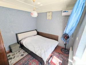 a small bedroom with a bed and a blue curtain at like at home in Yalanghoch