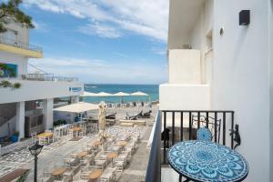 a balcony with a table and chairs and the beach at Sophisticated Paros Getaway in Parikia