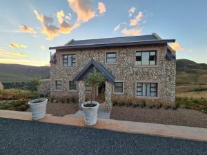 a stone house with two potted plants in front of it at 16 Bloulelie - The Bend County Estate -SUV in Rev Estates