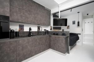 a large kitchen with a sink and a tv at Sophisticated Paros Getaway in Parikia +21 photos