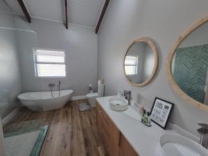 a bathroom with two sinks and a tub and a mirror at 16 Bloulelie - The Bend County Estate -SUV in Rev Estates +24 photos