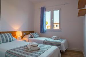 a room with two beds and a window at VILLA SAVINA in Cala en Blanes