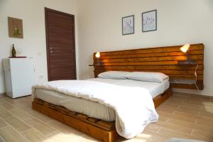 a bedroom with two beds and a wooden headboard at Villa delle Stelle in Cassaro +21 photos
