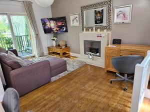 a living room with a couch and a fireplace at Stylish modern Cottage, Kidderminster in Kidderminster