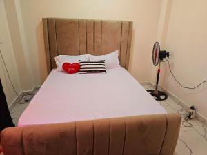 a bedroom with a large bed with a heart pillow at Vee stays in Mombasa