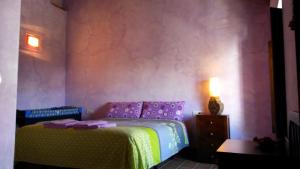 a bedroom with a purple bed and a table at Casa Rural del Rio in La Nava