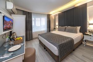 A bed or beds in a room at Beyazit Palace Hotel
