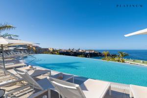 basen z leżakami i oceanem w obiekcie Landmar Playa La Arena w mieście Puerto de Santiago