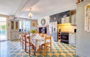 een keuken met een tafel en stoelen in een kamer bij Gîtes spacieux en Dordogne avec piscine partagée et jardin 140 m² in Bosset