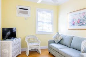 a living room with a couch and a tv at Deluxe King with Balcony - at James House with Parking! in Key West +20 photos
