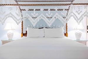 a bed with white pillows and a blue patterned headboard at Deluxe King with Balcony - at James House with Parking! in Key West