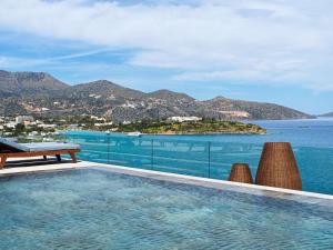 a swimming pool with a view of the ocean at NIKO Seaside Resort MGallery in Agios Nikolaos