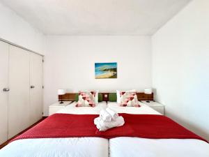 a bedroom with two beds with red and white sheets at Albufeira Skylight 2 by Homing in Vale de Pedras +21 photos