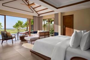a bedroom with a large white bed and a patio at voco Quang Binh Resort by IHG in Dong Hoi +81 photos