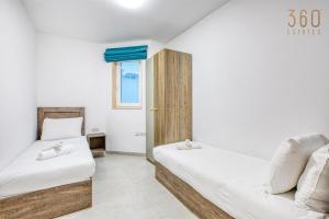 梅利哈Rooftop Pool Sensations Apartments all with WIFI and AC by 360 Estates的有两张床和一扇窗户的卧室