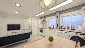 a large kitchen with a table and a tv at Apartamento Billa d Aro in Haro +12 photos