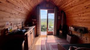 eine Küche mit großem Fenster in einer Holzhütte in der Unterkunft Hillside hideaway - Hendre-Aur Pod in Machynlleth