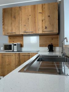 a kitchen with a sink and wooden cabinets at Casa Vacanze Ranuncolo 1 in Sùtrio +6 photos