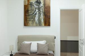 a painting of a woman on a wall above a bed at Umberto Home 303 in Catania