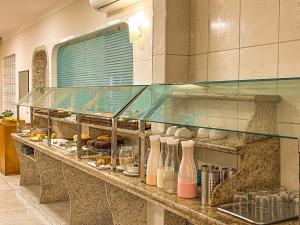 a display case in a kitchen with food on it at Hotel Nacional Inn Guarujá in Guarujá