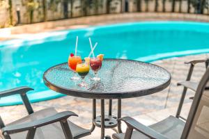 a table with two drinks on it next to a pool at Hotel Nacional Inn Guarujá in Guarujá