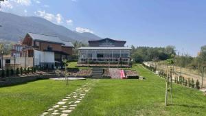 a large house with a lawn in front of it at Villa YoSi - rooms in Sapareva Banya