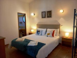 a bedroom with a bed with two towels on it at Quinta das AVES - Apartamento T2 com Piscina Comum in Odiáxere +18 photos