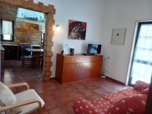 a living room with a red couch and a table at Quinta das AVES - Apartamento T2 com Piscina Comum in Odiáxere