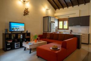 a living room with a red couch and a kitchen at The Jasmine House of Petra in Petra