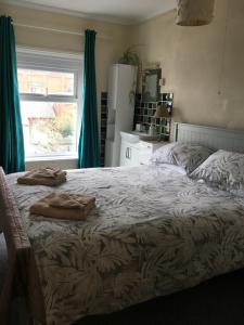 a bedroom with a bed with two towels on it at Whitecliff View in Sandown