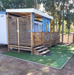 une cabane en bois avec un belvédère avec des escaliers et un porche dans l'établissement Camping Agde Mobil home 4 places , climatisé, à Agde