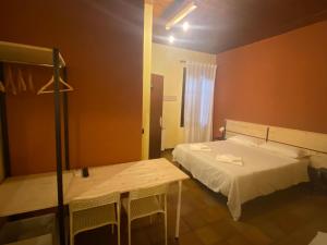 a bedroom with a bed and a table with chairs at affittacamere vallelunga in Pontelagoscuro