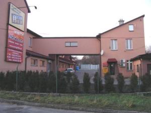 a pink building with a sign in front of it at Noclegi Viktor in Kalwaria Zebrzydowska