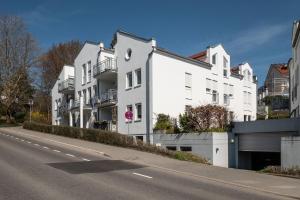 una fila de edificios blancos al lado de una carretera en Ferienwohnung Ella, en Meersburg