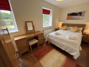 a bedroom with a bed and a desk and a mirror at Walled garden cottage in Hassocks