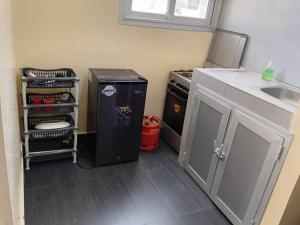 a kitchen with a black refrigerator and a sink at Appartement Beau Séjour in Dakar +25 photos