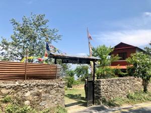 ein Gebäude mit einem Schild vor einer Steinmauer in der Unterkunft Hotel Mountain Nest in Nagarkot