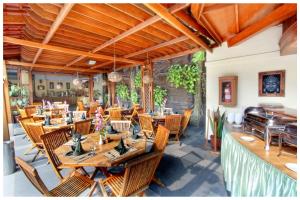 a restaurant with wooden tables and chairs and a piano at Mutiara Hotel and Convention in Bandung